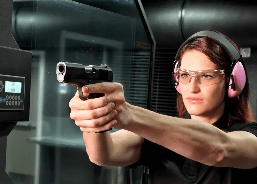 A woman practicing firing on a shooting range